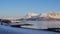 View at the island of Senja and the fjord in the Atlantic Ocean with a snowy field in the polar area and mountains covered in snow