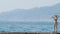 View of the islands in the bay. Telephoto shot. woman on the breakwater looks at the seashore in the fog, 4k, slow