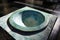 View on isolated green blue old medieval marble stone baptismal font illuminated by natural sunlight in catholic church - Brugge,