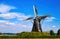 View on isolated typical dutch windmill Molen de grauwe beer in rural landscape against deep blue summer sky with cumulus clouds