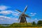 View on isolated typical dutch windmill Molen de grauwe beer in rural landscape against deep blue summer sky with cumulus clouds