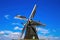 View on isolated typical dutch windmill Molen de grauwe beer in rural landscape against deep blue summer sky with cumulus clouds