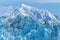 A view of the jagged top of the Hubbard Glacier snout with mountain backdrop in Alaska