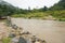 View of Jungle and Mountain Peaks and Small River in Malaysia Rain Forest with Cloudy Stormy Sky. Lush Green Jungle Vegetation and