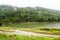 View of Jungle and Mountain Peaks and Small River in Malaysia Rain Forest with Cloudy Stormy Sky. Lush Green Jungle Vegetation and