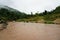 View of Jungle and Mountain Peaks and Small River in Malaysia Rain Forest with Cloudy Stormy Sky. Lush Green Jungle Vegetation and