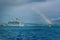 View of Kerkyra port on Corfu Island, Greece - large white cruise ship and bright rainbow on the sky