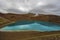 View at Krafla volcanic crater and Viti lake in northern Iceland, vapor of geothermal power plant unit is at background