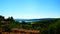 View of Lake Bracciano from a height with plants and trees and roofs with tiles in the foreground