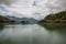 View of lake Colibita surrounded by hills with green vegetation. Romania.