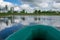 View of the lake landscape from the green rubber boat to the shore, fishing tackle