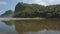 The view of the lake is shallow with lots of rocks and has a murky water color and also mountains that rise very high and overgrow