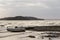 View of a lake shore on a moody day, with a little boat, islands