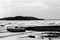 View of a lake shore on a moody day, with a little boat, islands