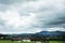 View landscape of mountain and grass field beside road at countryside