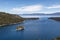 View of Large Bay and Lake with Boats, Small Island, Trees and Mountains.