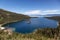 View of Large Bay and Lake with Boats, Small Island, Trees and Mountains.