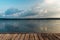 View of a large calm lake at sunset from wooden pier