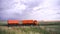 View of large-capacity truck with body traveling on rural road through farm fields. Scene. Landscape steppe and field