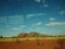 A view of large desert canyon rocks from a bus window