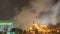 View of a large factory or plant in the light of night lighting. A lot of smoke comes out of the factory\\\'s chimneys.