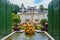 View of the lateral faÃ§ade of Linderhof Castle with a water basin and a gilded sculpture