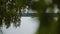 View through the leaves of trees on a boat floating on the lake. Water walk.