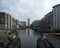 a view of leeds dock from the lock gates showing waterside developments offices and apartment buildings with houseboats moored in