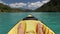 View of legs of a man slowly swaying in yellow kayak on an emerald lake. A traveler is resting and enjoying a view of