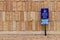 View of a library parking sign in front of an modern limestone wall with rough texture bricks