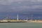 View on lighthouse and modern construction cranes against stormy sky in Ostend, Belgium