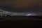 View of lightning strike over a rural farm field, lightning strikes the ground, strong thunder, lightning, dark clouds in the sky