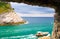 View of Ligurian sea water, rock cliff of Palmaria island and yacht through brick stone wall window, Portovenere