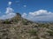 View of limestone tower Perda Liana, impressive rock formation on green forest hill, sardinian table mountain. National Park of