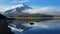 View of the Limpiopungo lagoon with the Cotopaxi volcano reflected in the water on a cloudy morning
