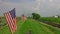 View of a Line of Gently Waving American Flag on a Fence by Farmlands as a Steam Passenger Train Blowing Smoke