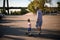 View of little girl riding skateboard while her father walks beside