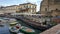 View of the little marina and touristic harbor near Castel Nuovo New Castle with restaurants and terraces, City of Naples, Italy