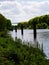 View on a little river and a bridge and a tree area and with sky with white clouds