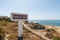 View of a location sign on the shores of Ponta do Trovao under the blue sky