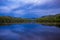 A view of Loch Faskally from the Pitlochry Dam wall at sunset, with a reflection