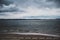 View of Long Beach seaside walk on a stormy spring day with dark moody sky and intense tones in the water