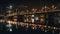 A view on a long bridge at night above a large river