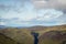 View looking east above Glen Doll towards rolling Scottish mountains with white clouds