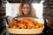 View Looking Out From Inside Oven As Woman Cooks Sunday Roast Chicken Dinner