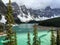 A view looking over Moraine Lake, in Jasper National Park, Alberta, Canada. The sun is peaking through the grey clouds and