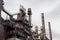 View looking up at old steel mill exterior, layers of walkways, stairs, and smokestacks