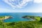 A view of the Lulworth Cove along the Jurrassic Coast in Dorset under a majestic blue sky and some white clouds