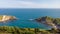 A view of the Lulworth Cove along the Jurrassic Coast in Dorset under a majestic blue sky and some white clouds