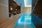 View of the luxurious modern interior of the spa and wellness center with sun loungers by the thermal pool with underwater
